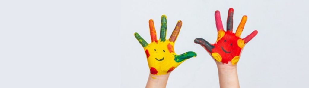 Foto de manos de niño o niña pintadas con caras felices