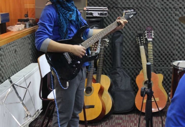 Foto estudiante tocando la guitarra