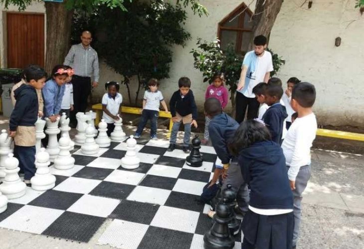 Foto de niñs jugando ajedrez gigante