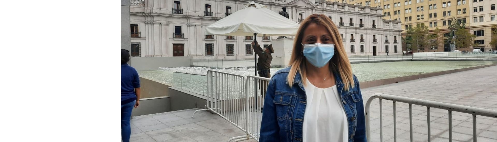 En la imagen se ve a la docente Paola Saavedra, creadora del canal de YouTube, en frente del Palacio de La Moneda en Santiago, Chile.