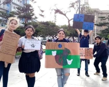 Profesora Mery con sus estudiantes realizando activismo medioambiental en la calle