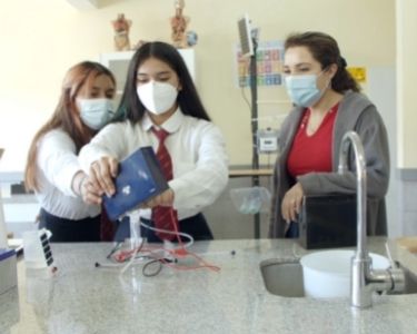 Foto de la profesora Militza Saavedra con dos de sus estudiantes en una clase de innovación. Foto de La Ventana