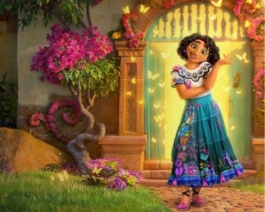 Imagen del personaje Mirabel Madrigal, protagonista de la película de Disney Encanto. En la imagen se ve de fondo una casa llena de flores.