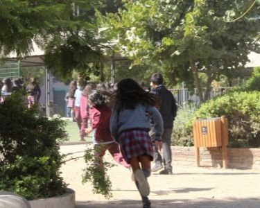 Fotografía de varios estudiantes en movimiento (corriendo), en el patio del Colegio Jorge Huneeus Zegers. En demostración del regreso a las clases presenciales tras 2 años de pandemia